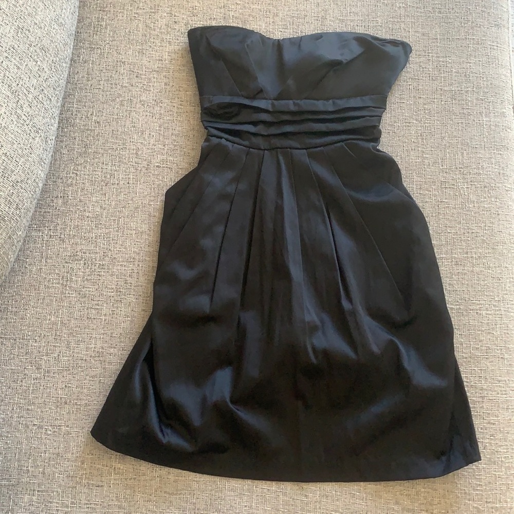 Like new strapless black dress with side pockets, zipper, and ribbon for bow